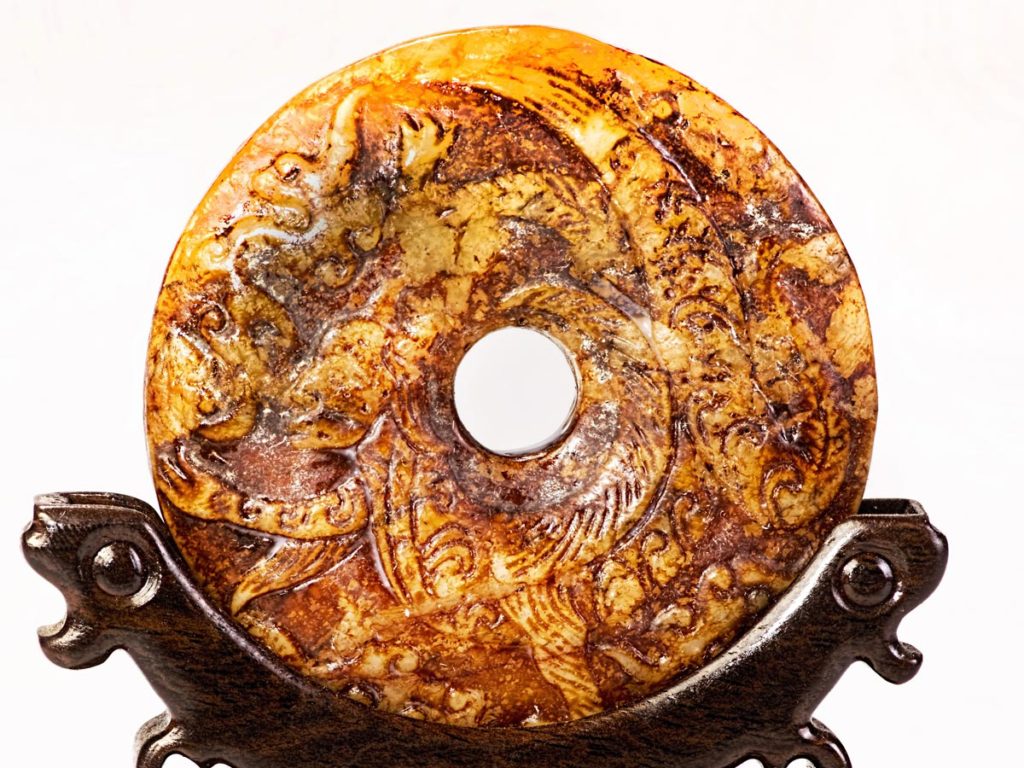 A Chinese 璧 (bi wheel) of orange and yellow jade.